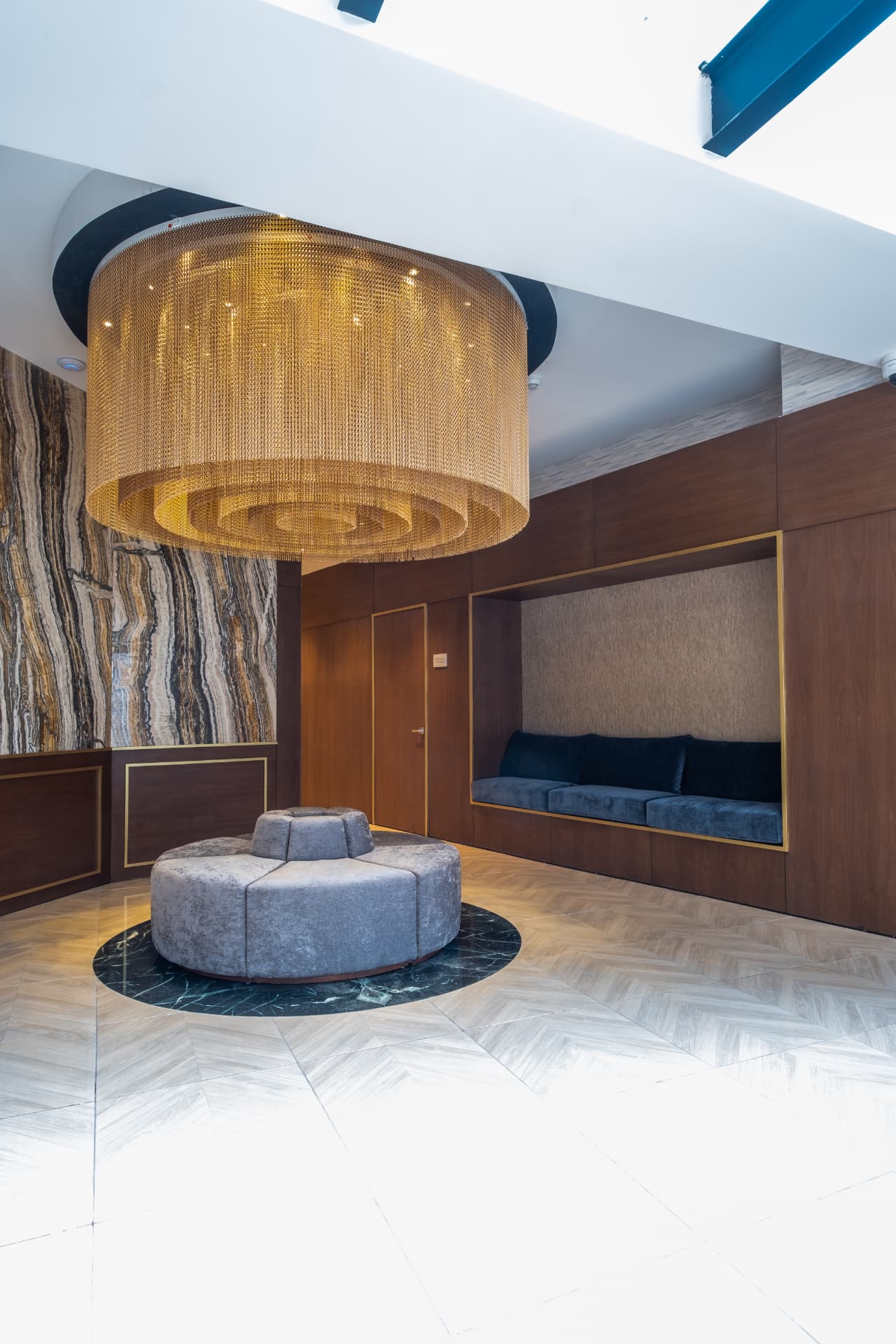 Lobby de Los Pinos Rentals con lámpara dorada, asientos y acabados de piedra y madera
